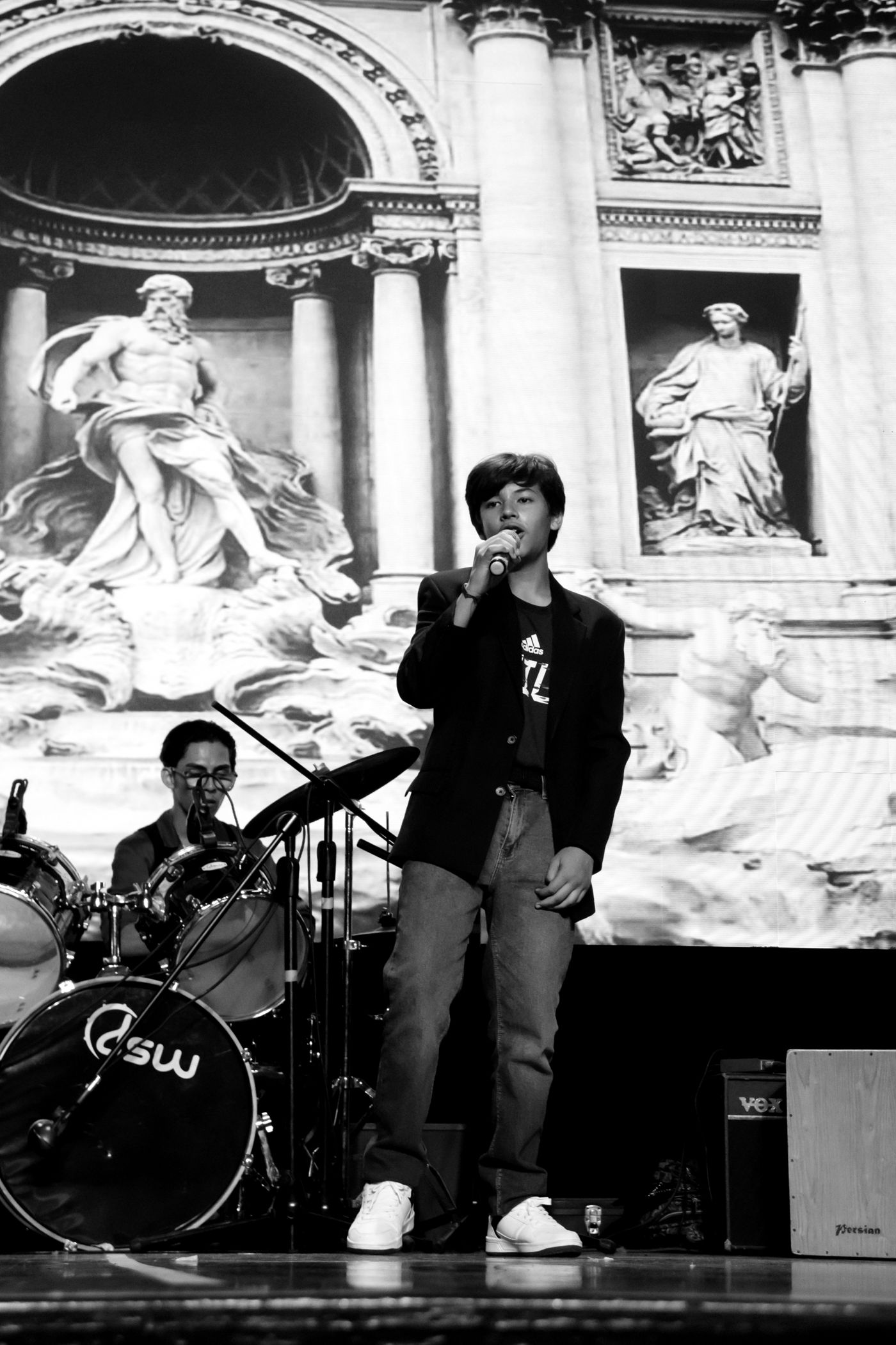 Estudiante cantando frente a un telón de la Fontana di Trevi